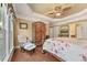 Spacious main bedroom featuring tray ceilings, a ceiling fan, a sitting area, and backyard views at 4535 Vanadium Bnd, Cumming, GA 30040