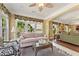 Inviting sunroom with a comfortable sofa, wicker table, and a view into the main living space at 4535 Vanadium Bnd, Cumming, GA 30040