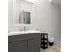Bathroom with silver framed mirror, gray vanity, and laminate floors at 5150 Wheat Ne St, Covington, GA 30014