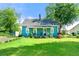 Charming blue home featuring a well-manicured lawn, lovely landscaping, and inviting front porch at 5150 Wheat Ne St, Covington, GA 30014