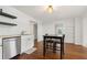 Eat-in kitchen with hardwood floors, stainless steel dishwasher, and white cabinets at 5150 Wheat Ne St, Covington, GA 30014