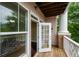 View of a private balcony with an open door and white railing overlooking a wooded area at 1965 Nocturne Dr # 1306A, Alpharetta, GA 30009