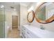 Bright bathroom featuring a double sink vanity with decorative round mirrors and a glass shower at 1965 Nocturne Dr # 1306A, Alpharetta, GA 30009