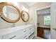 Bathroom with a dual sink vanity, decorative mirrors, and access to the bedroom at 1965 Nocturne Dr # 1306A, Alpharetta, GA 30009