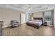Spacious main bedroom with a tray ceiling, wood-look floors, and a cozy armchair at 502 Stoneland Pl, Lawrenceville, GA 30046