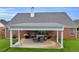 Brick home with a covered patio featuring outdoor seating and a grill, perfect for entertaining at 502 Stoneland Pl, Lawrenceville, GA 30046