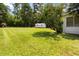 A spacious backyard features a large lawn, storage shed, and beautiful trees at 8185 Rivertown Rd, Fairburn, GA 30213