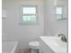 All-white bathroom featuring a shower/tub, tiled walls, vinyl floors, a large mirror, and a toilet at 8185 Rivertown Rd, Fairburn, GA 30213