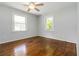 Bedroom featuring hardwood floors, light paint, two windows, and a ceiling fan at 8185 Rivertown Rd, Fairburn, GA 30213