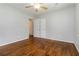 Bedroom featuring two white doors, hardwood floors, a ceiling fan, and light paint at 8185 Rivertown Rd, Fairburn, GA 30213