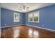 Comfortable bedroom with wood floors, natural light, and ceiling fan, offering a serene retreat at 8185 Rivertown Rd, Fairburn, GA 30213