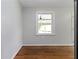 An empty dining room features hardwood floors, light paint, and a window looking out to the deck and backyard at 8185 Rivertown Rd, Fairburn, GA 30213