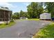 Long paved driveway with green lawns and sheds in the background at 8185 Rivertown Rd, Fairburn, GA 30213
