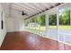 Spacious screened-in porch with painted wood flooring and ceiling fan, overlooking the yard at 8185 Rivertown Rd, Fairburn, GA 30213