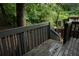 A dark, wooden back deck is surrounded by lush greenery and trees at 936 Glynn Oaks Dr, Clarkston, GA 30021