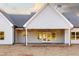 Rear view of a home with light siding, dark roof, and covered back porch at 269 Highway 11, Social Circle, GA 30025