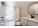 A bathroom with a white vanity, bathtub, black hardware and a round mirror at 269 Highway 11, Social Circle, GA 30025
