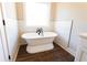 Bright bathroom featuring a luxurious soaking tub with oil-rubbed bronze fixtures and tiled walls at 269 Highway 11, Social Circle, GA 30025
