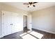 Bedroom featuring a ceiling fan, double door closet, and dark wood-look flooring at 269 Highway 11, Social Circle, GA 30025