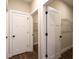 Hallway featuring three doors with black hardware and walk-in closets with wire shelving at 269 Highway 11, Social Circle, GA 30025