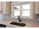 A kitchen window is above a stainless steel sink, which features granite countertops and subway tile backsplash at 269 Highway 11, Social Circle, GA 30025