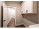 Bright laundry room with storage cabinets and dark wood-look flooring at 269 Highway 11, Social Circle, GA 30025
