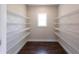 A walk-in pantry features custom-built shelving with a window at 269 Highway 11, Social Circle, GA 30025