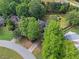 Aerial view of the home nestled among mature trees with an expansive backyard and neighboring houses at 4365 Wicklow Ct, Suwanee, GA 30024