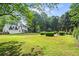 Spacious backyard with lush green lawn, mature trees, and inviting outdoor seating areas at 4365 Wicklow Ct, Suwanee, GA 30024