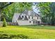 Expansive grassy backyard with mature trees, an outdoor patio, and a charming fire pit area at 4365 Wicklow Ct, Suwanee, GA 30024