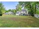 Expansive backyard featuring a manicured lawn, mature trees, and a patio with outdoor seating at 4365 Wicklow Ct, Suwanee, GA 30024