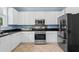 A modern kitchen featuring stainless steel appliances, granite countertops and white cabinets at 4365 Wicklow Ct, Suwanee, GA 30024