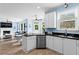 Modern kitchen with white cabinets, stainless steel appliances, granite counters flows into living room with fireplace at 4365 Wicklow Ct, Suwanee, GA 30024