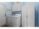 Clean laundry room features a front load washer, dryer and built-in cabinets at 4365 Wicklow Ct, Suwanee, GA 30024