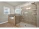 Spa-like bathroom with tiled shower, tiled tub, and sleek glass door at 4511 Bridgeway Rd, Atlanta, GA 30331