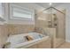 Relaxing bathroom with a soaking tub, tiled walls, and a separate glass-enclosed shower at 4511 Bridgeway Rd, Atlanta, GA 30331