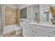 Well lit bathroom with a large mirror, white cabinets, and tiled shower/tub combo at 4511 Bridgeway Rd, Atlanta, GA 30331