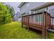 View of the backyard deck with wood railing, accessible through sliding glass doors and overlooking the green yard at 6590 Smoke Ridge Dr, Atlanta, GA 30349