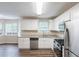 Modern kitchen featuring stainless steel appliances, granite countertops, white cabinets, and hardwood floors at 6590 Smoke Ridge Dr, Atlanta, GA 30349