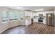 Bright eat-in kitchen featuring stainless steel appliances, granite countertops, white cabinets, and hardwood floors at 6590 Smoke Ridge Dr, Atlanta, GA 30349