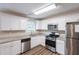 Well-lit kitchen featuring stainless steel appliances, granite countertops, white cabinets, and hardwood floors at 6590 Smoke Ridge Dr, Atlanta, GA 30349