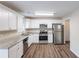 Spacious kitchen featuring stainless steel appliances, granite countertops, white cabinets, and hardwood floors at 6590 Smoke Ridge Dr, Atlanta, GA 30349