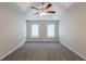 Main bedroom with plush carpet, ceiling fan, and windows at 6590 Smoke Ridge Dr, Atlanta, GA 30349