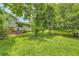 Lush backyard features a sprawling lawn and beautiful mature trees, providing ample shade at 3551 Cindy Way, Rex, GA 30273