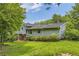 Green backyard with ample shade provided by mature trees, with a view of the home's exterior at 3551 Cindy Way, Rex, GA 30273