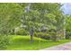 Beautiful home with lush landscaping, mature trees, green lawn, and brick accents on the front facade at 3551 Cindy Way, Rex, GA 30273