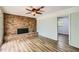 Inviting living room features a brick fireplace, ceiling fan, and stylish wood-look flooring at 3551 Cindy Way, Rex, GA 30273