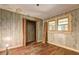 Bedroom with outdated wood-paneled walls and worn hardwood floors at 6191 Cumming Hwy, Canton, GA 30115