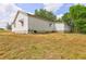 Angle showing the side of the house with an overgrown lawn in the foreground at 6191 Cumming Hwy, Canton, GA 30115