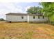 Back exterior of the house showing a large lot and some overgrown landscaping at 6191 Cumming Hwy, Canton, GA 30115